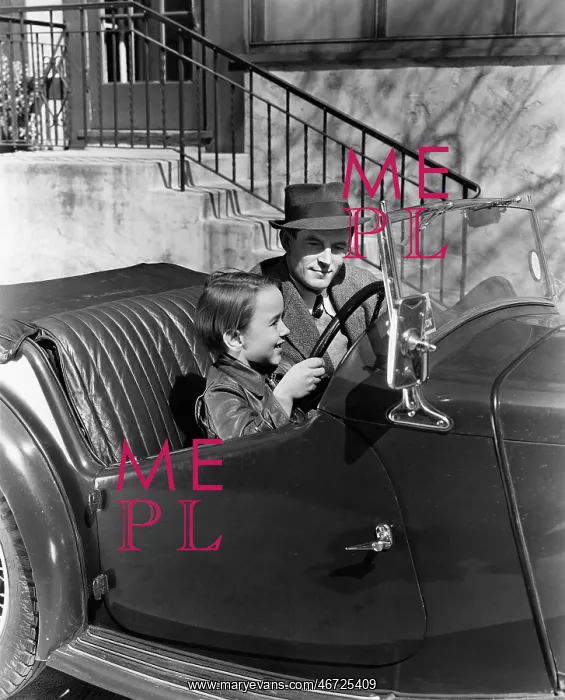 : Young boy sitting in the driver's seat of car with : Young boy sitting in the driver's seat of car with