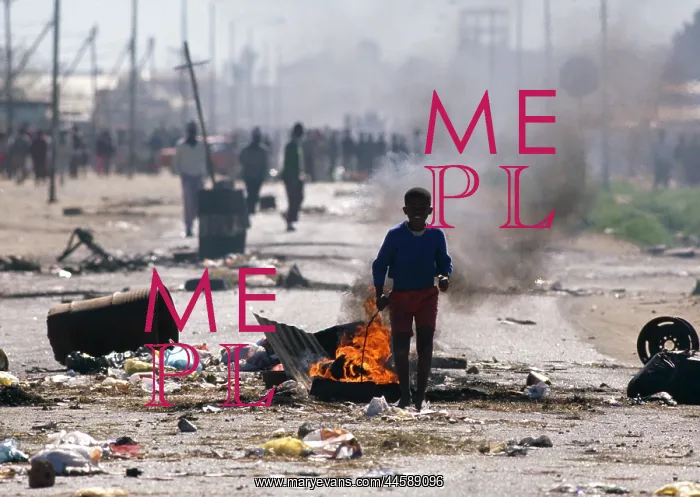 : A young boy stand in front of a smoky tyre fire : A young boy stand in front of a smoky tyre fire