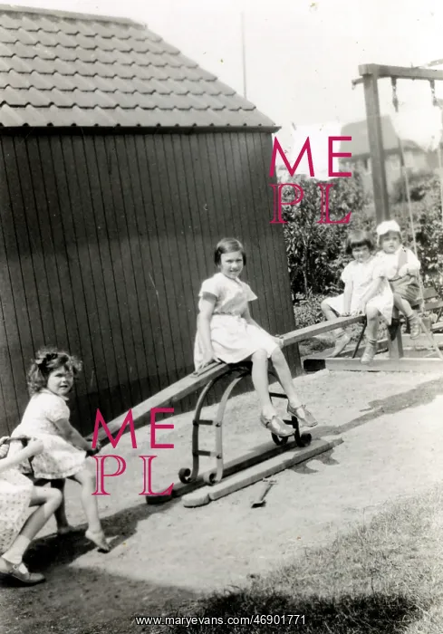 : Four young children playing on a see-saw : Four young children playing on a see-saw