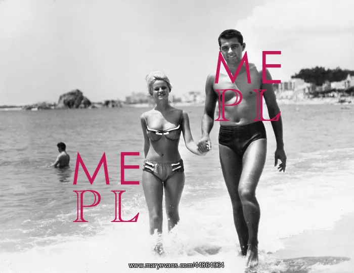 : Young couple walking along a beach, Spain : Young couple walking along a beach, Spain
