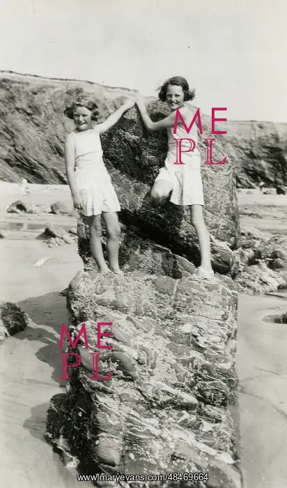 : Two young girls playing on the rocks on a Cornish beach : Two young girls playing on the rocks on a Cornish beach