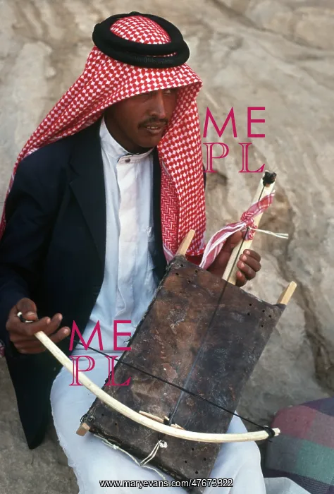 : A young Jordanian man plays a rababah : A young Jordanian man plays a rababah