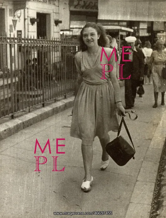 : Young lady strolling confidently along, swinging her handbag : Young lady strolling confidently along, swinging her handbag