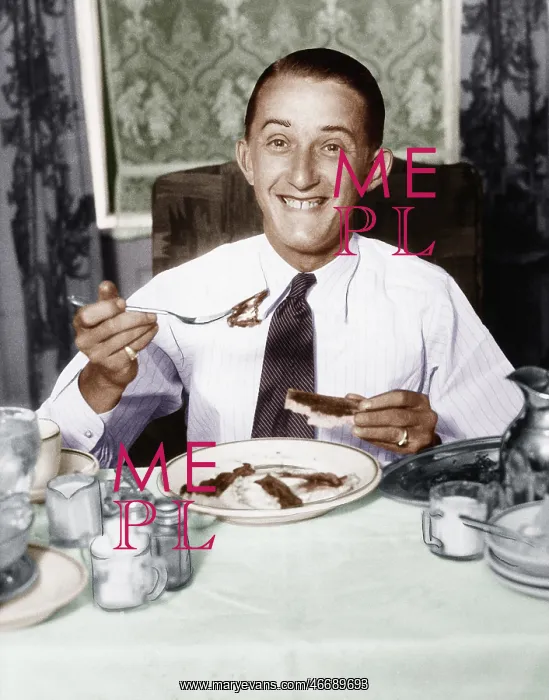 : Young man having breakfast and smiling : Young man having breakfast and smiling