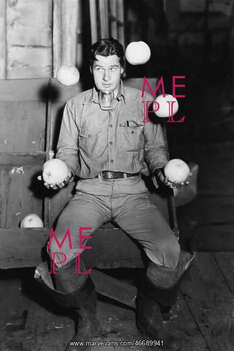 : Young man juggling with oranges and balancing a : Young man juggling with oranges and balancing a