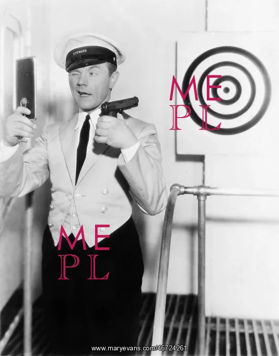 : Young man looking at a mirror and aiming at a dartboard : Young man looking at a mirror and aiming at a dartboard