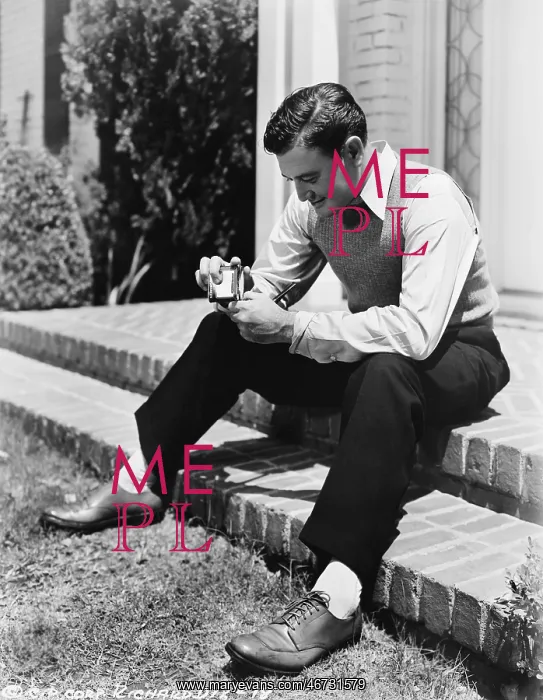 : Young man sitting on a step and holding a cigarette : Young man sitting on a step and holding a cigarette
