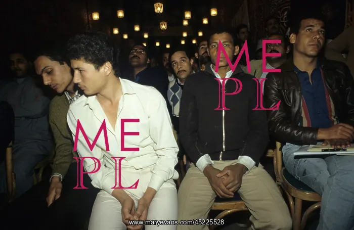 : Young men listening to a speech at a rally ? : Young men listening to a speech at a rally ?