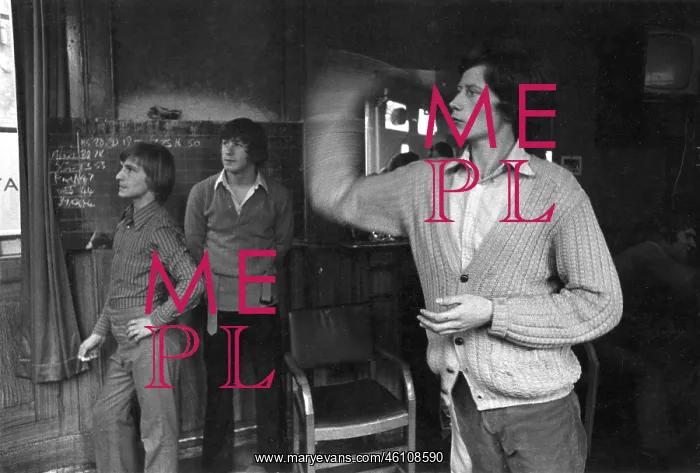 : Three young men playing darts in a pub : Three young men playing darts in a pub
