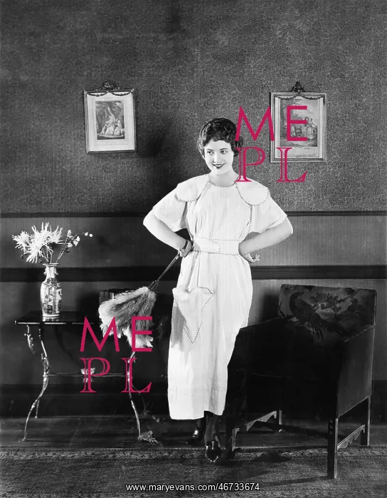 : Young woman in an apron and a duster standing in : Young woman in an apron and a duster standing in