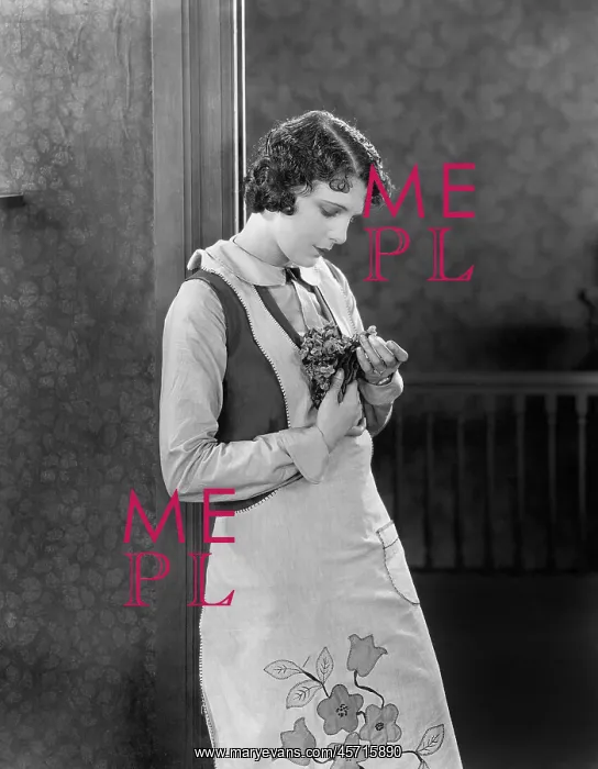 : Young woman in an apron holding herbs : Young woman in an apron holding herbs