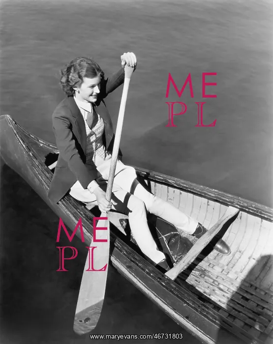 : Young woman in a canoe rowing : Young woman in a canoe rowing