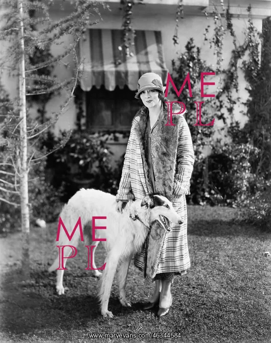 : Young woman in coat and hat standing outside with : Young woman in coat and hat standing outside with