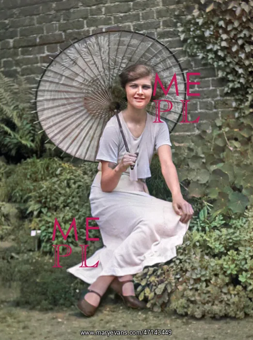 : Young woman in a garden with a parasol : Young woman in a garden with a parasol