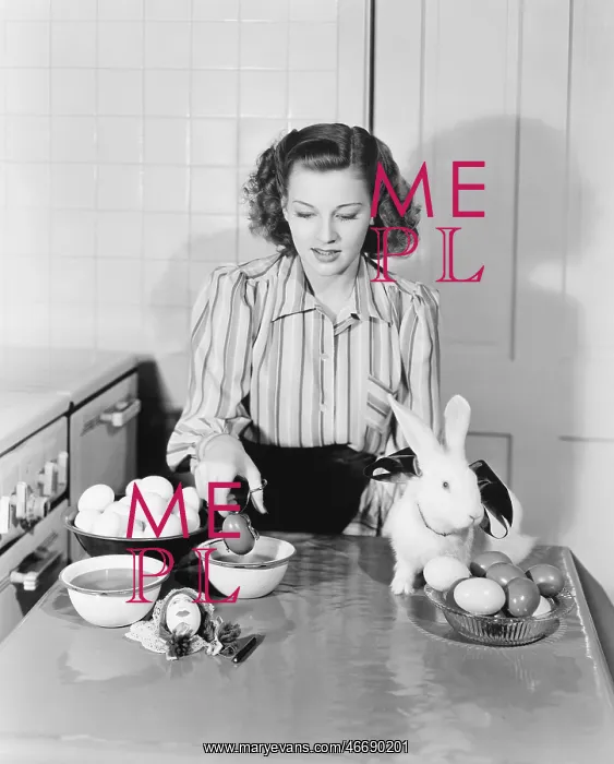 : Young woman in her kitchen coloring Easter eggs