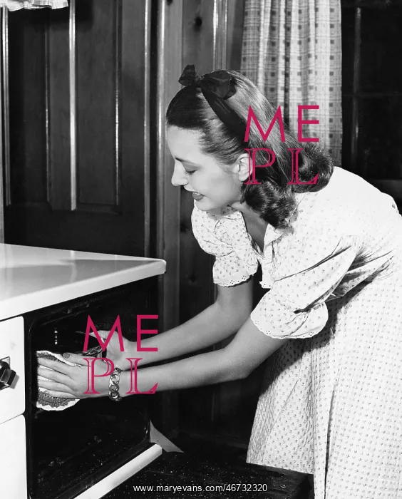 : Young woman in her kitchen pulling a pot out of the oven : Young woman in her kitchen pulling a pot out of the oven