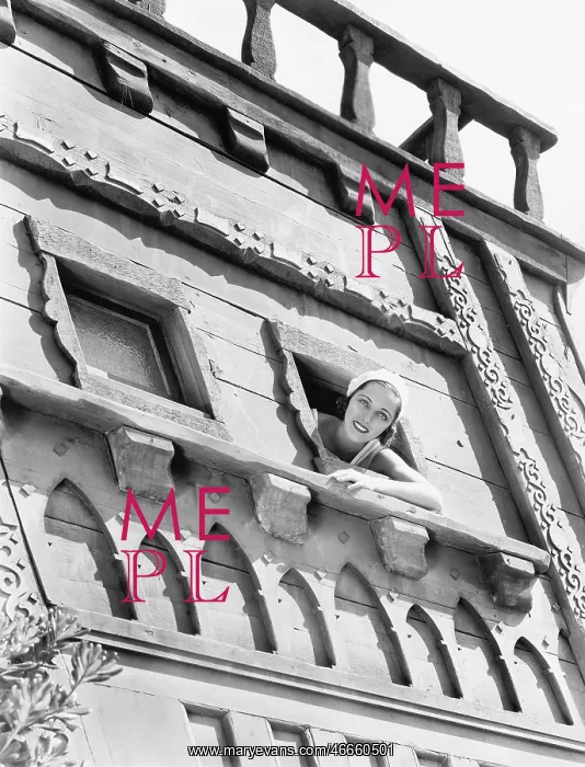 : Young woman looking out of an window of an castle : Young woman looking out of an window of an castle