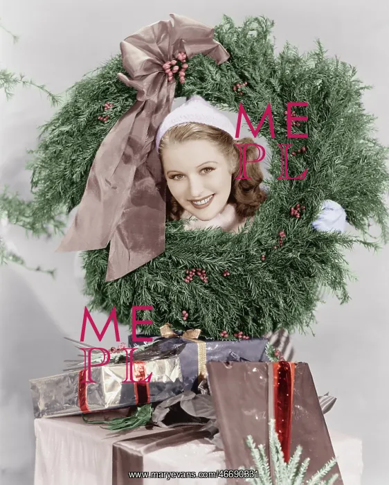 : Young woman looking through a wreath with presents : Young woman looking through a wreath with presents