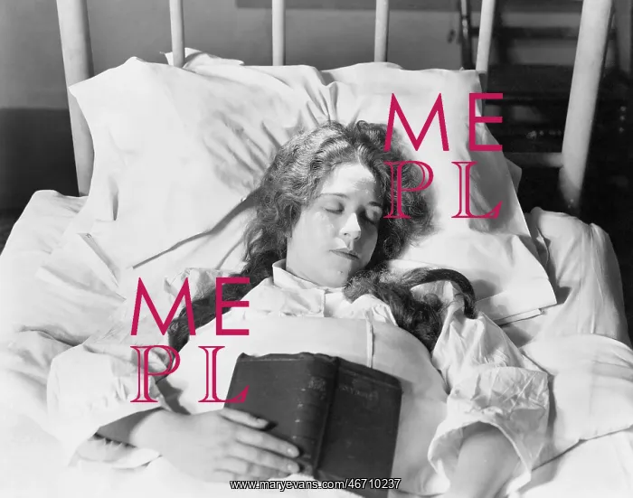 : Young woman lying in bed, sleeping and holding a book : Young woman lying in bed, sleeping and holding a book