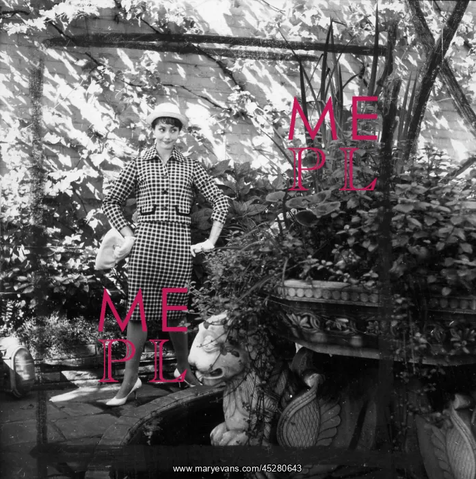 : Young woman modelling a suit in a garden : Young woman modelling a suit in a garden