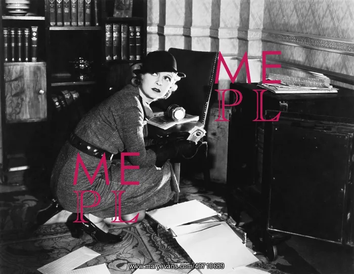 : Young woman in an office next to a safe, looking : Young woman in an office next to a safe, looking