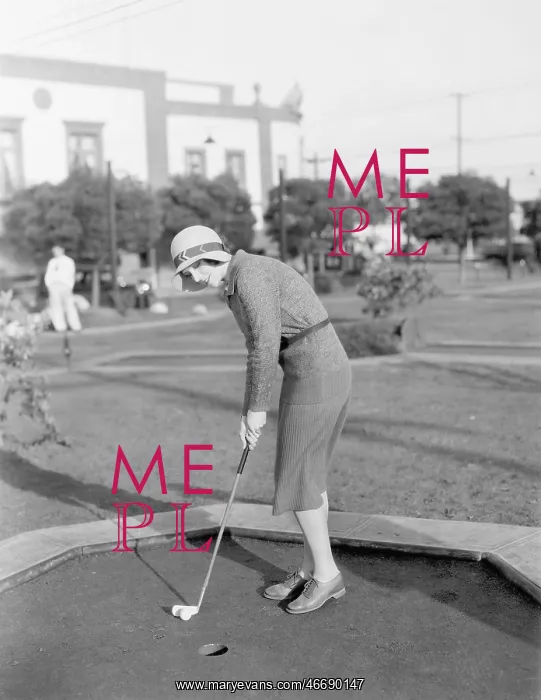 : Young woman playing mini golf : Young woman playing mini golf