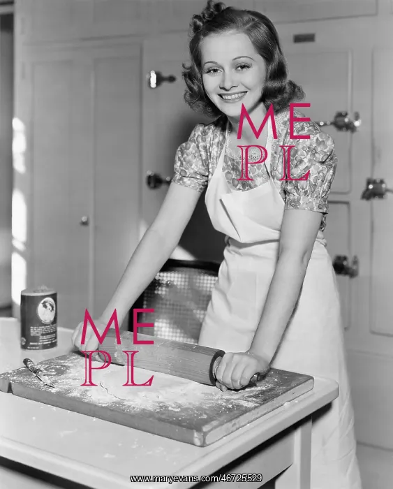 : Young woman rolling out dough in the kitchen : Young woman rolling out dough in the kitchen