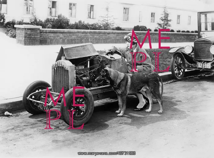 : Young woman sitting next to small car looking at : Young woman sitting next to small car looking at