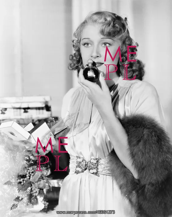 : Young woman smelling perfume : Young woman smelling perfume