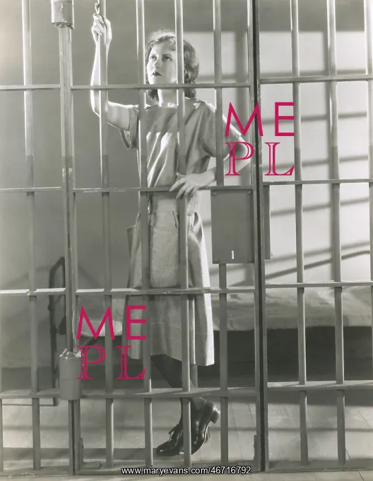 : Young woman standing in prison cell : Young woman standing in prison cell