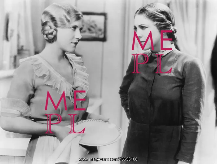 : Two young woman talking with each other while doing : Two young woman talking with each other while doing