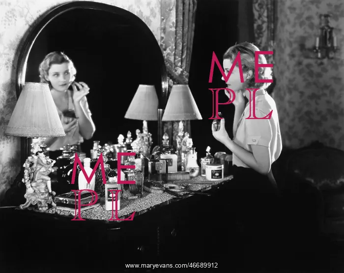 : Young woman in front of her vanity applying make-up : Young woman in front of her vanity applying make-up