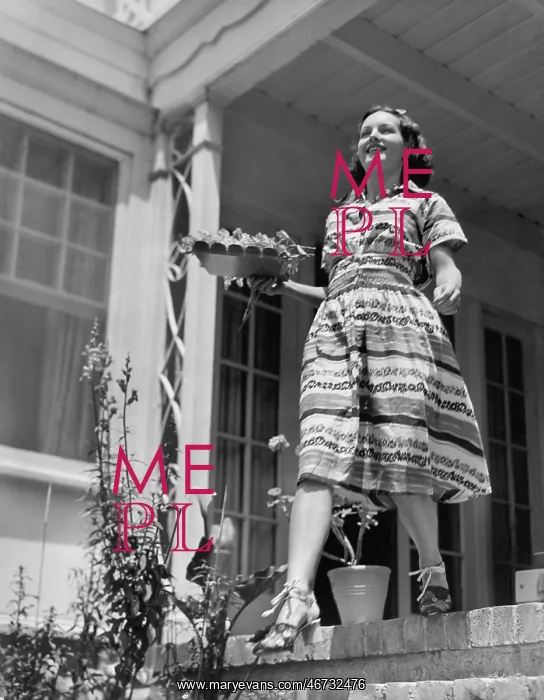 : Young woman walking down steps of her terrace with : Young woman walking down steps of her terrace with