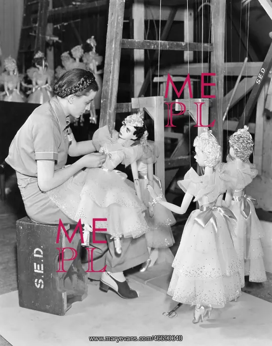 : Young woman working with puppets on a string : Young woman working with puppets on a string