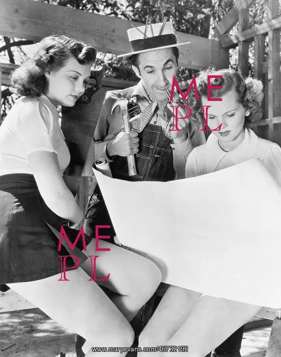 : Two young women and a man looking at architectural plans : Two young women and a man looking at architectural plans