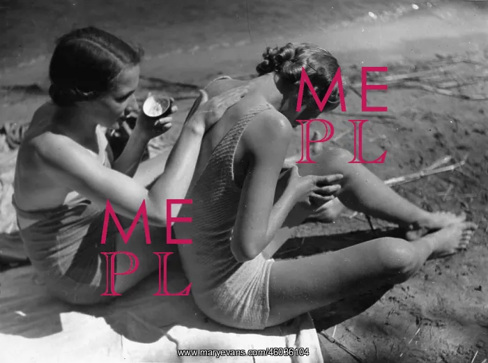 : Two young women putting sunscreen on : Two young women putting sunscreen on