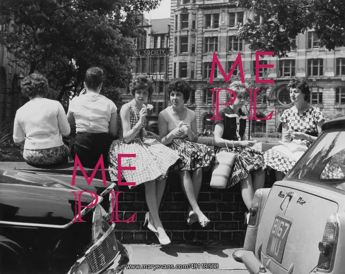 : Young women sitting on a wall : Young women sitting on a wall
