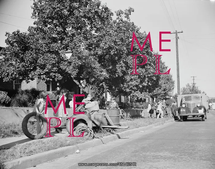 : Youngsters help load a truck with scrap metal : Youngsters help load a truck with scrap metal
