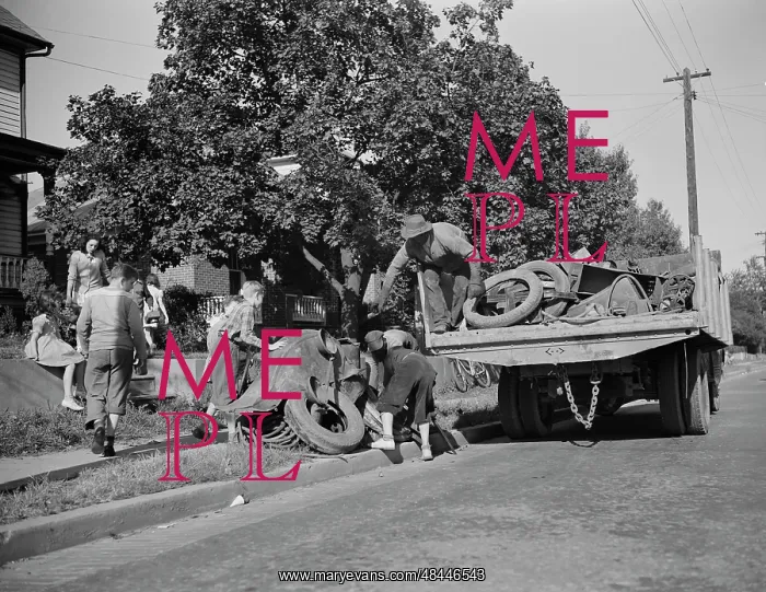 : Youngsters help load a truck with scrap metal : Youngsters help load a truck with scrap metal
