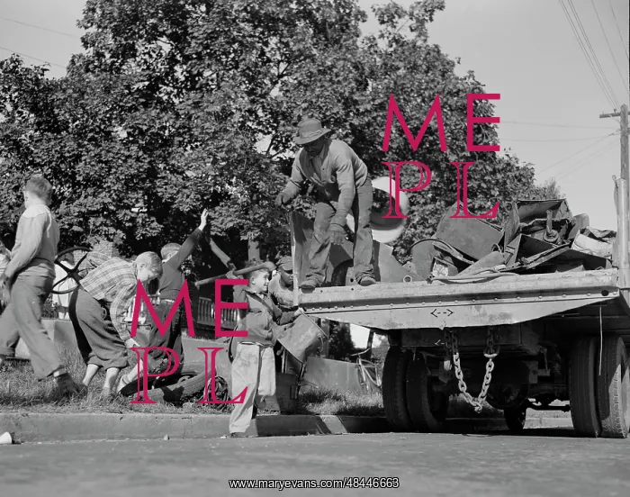: Youngsters help load a truck with scrap metal : Youngsters help load a truck with scrap metal