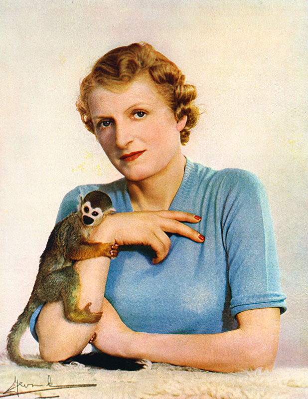 Lady Broughton (1894-1968), the first wife of Sir Jock Delves Broughton with her squirrel monkey, Mr. Winks, whom she brought from British Guiana in 1938. Previously Miss Vera Griffith-Boscawen, she married Jock in 1913 and divorced him in 1940 (he would go on to marry Diana Caldwell and stand trial for the murder of her lover, Josslyn Hay, Earl of Erroll in Kenya). Vera travelled widely in South East Asia and was known as a big game hunter and fisherwoman. She was also a highly regarded photographer of natural subjects. Date: 1939