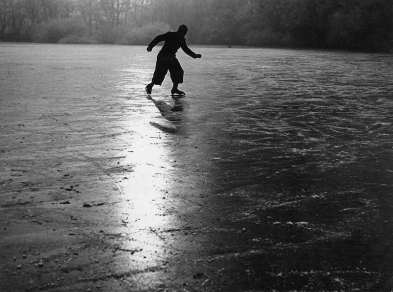 A solitary ice skater making patterns on the ice of a frozen river.
1950s