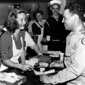 Bette Davis serving cake to US servicemen at the Bette Davis serving cake to US servicemen at the