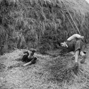 Two boys playing near a haystack Two boys playing near a haystack