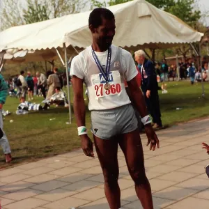 British Caribbean marathon runner standing with medal British Caribbean marathon runner standing with medal