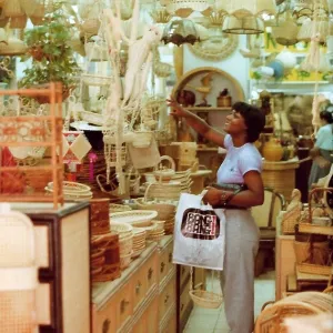 British Caribbean woman points to an item, novelty shop, Hon British Caribbean woman points to an item, novelty shop, Hon