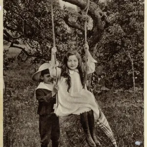 Brother and Sister playing on a swing Brother and Sister playing on a swing