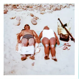 Couple sunbathing on a sandy beach Couple sunbathing on a sandy beach