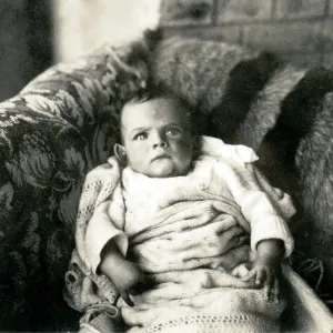 Cross looking baby on a sofa Cross looking baby on a sofa