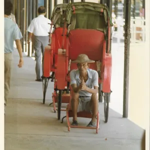 Elderly Chinese man in an empty red rickshaw Elderly Chinese man in an empty red rickshaw
